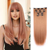 Une femme modélise une longue extension de cheveux roses pâles lisses avec des pinces noires et un jeu d'extensions séparé.