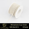 A spool of rhinestone cup chain in a gold color with 10 yards of material.