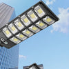 A black floodlight fixture with multiple LED bulbs is mounted on a building, illustrating intelligent recognition day and nig