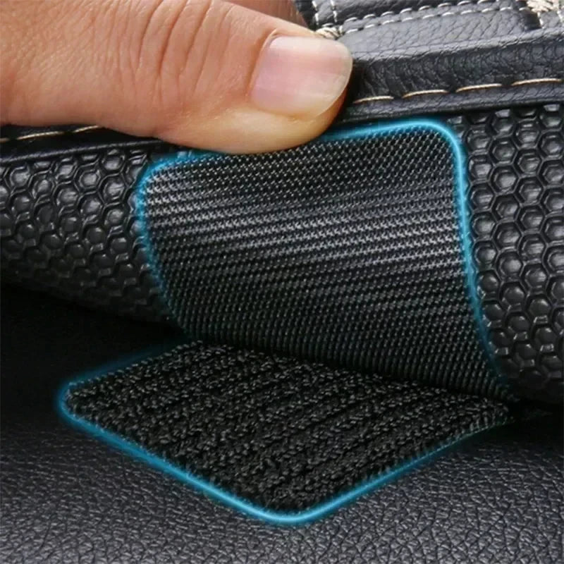 Close-up of black leather material with blue adhesive patches and a hand touching the fabric.