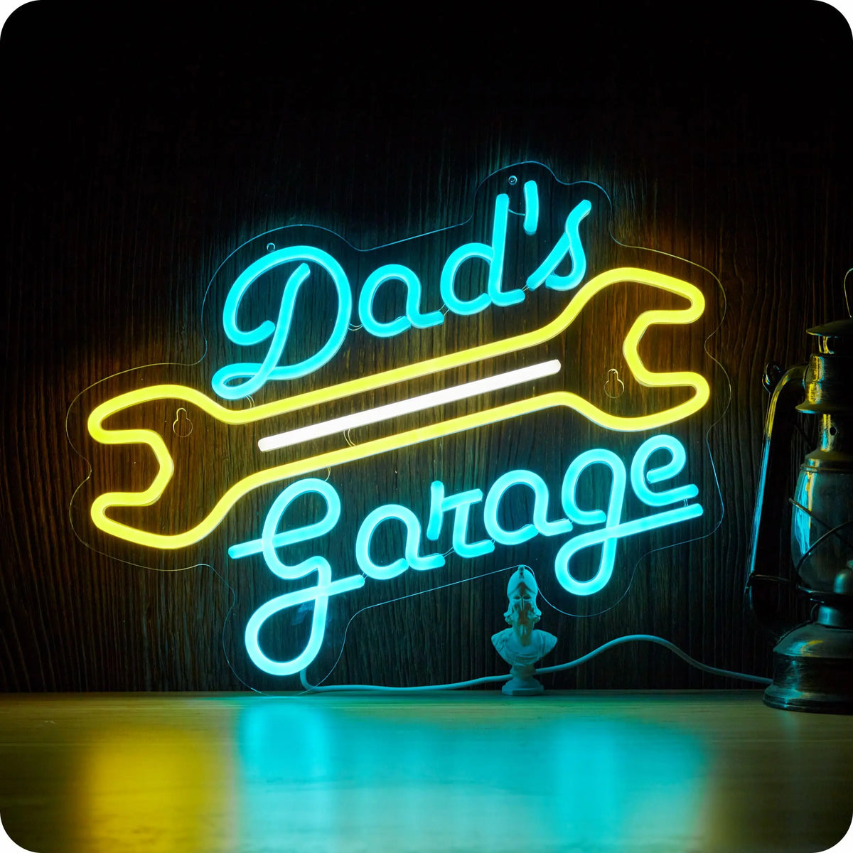 Neon sign spelling out Dad's Garage in bright blue light on a wooden wall.