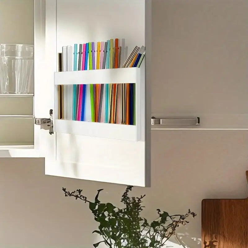 A white acrylic straw dispenser with an adhesive mount displaying various colored straws.