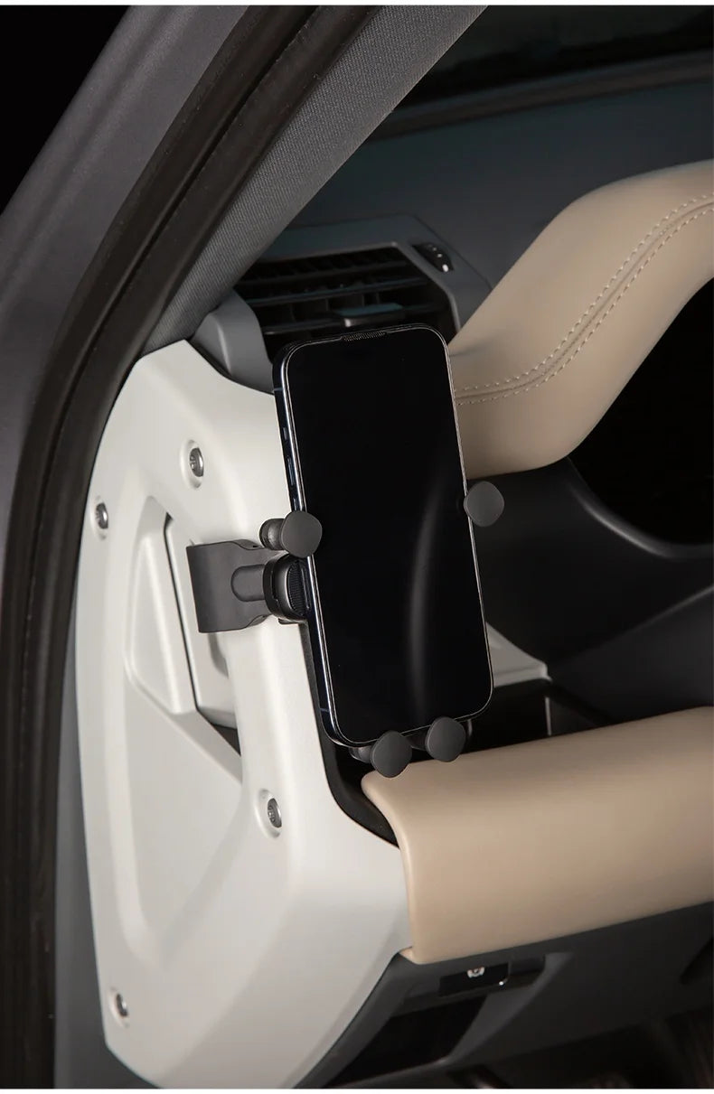 A magnetic car phone mount with a cup holder base is shown mounted in a vehicle interior.