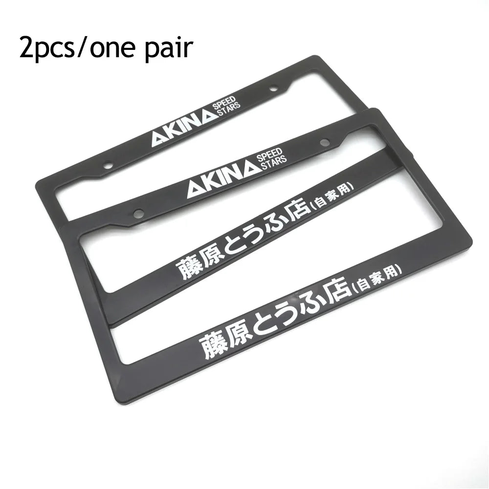 A pair of black racing style license plate frames with AKINA SPEED STARS branding.