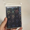A pack of holographic heart-shaped card sleeves in a clear plastic sleeve.