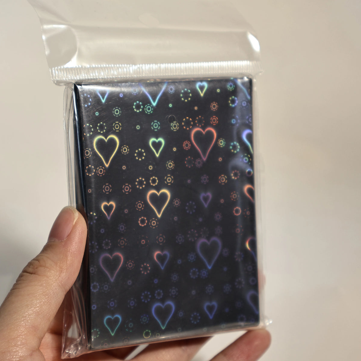 A pack of holographic heart-shaped card sleeves in a clear plastic sleeve.
