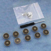 A collection of silver instant no-sew snap buttons laid out on a translucent white bag.