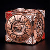 A bronze metal spinner dice cube featuring a dragon design and numbered faces, displayed on a dark surface.