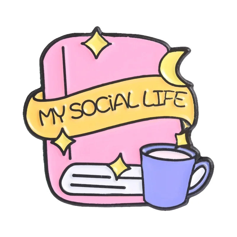 Enamel pin featuring a pink book with a yellow ribbon and a purple mug, titled My Social Life.
