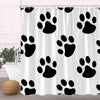 A white fabric shower curtain featuring a repeating pattern of black paw prints.
