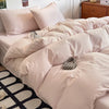 A close-up of a beige ultra-soft washed cotton duvet cover set featuring a duvet and pillows on a bed.