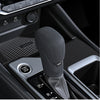 A close-up view of a black silicone gear shift cover for a Nissan vehicle.