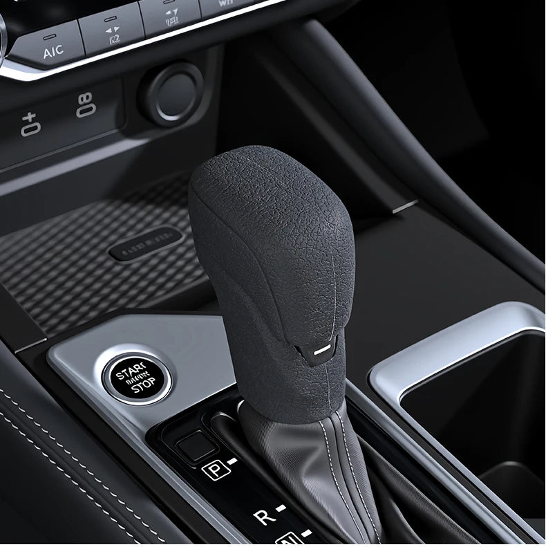 A close-up view of a black silicone gear shift cover for a Nissan vehicle.