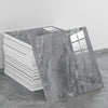 A rectangular panel of gray marble effect self-adhesive PVC tile displayed next to a stack of white tiles.