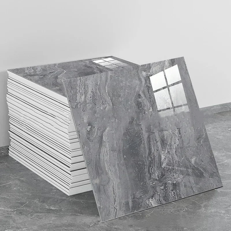 A rectangular panel of gray marble effect self-adhesive PVC tile displayed next to a stack of white tiles.