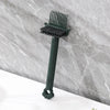 A dark green dual-sided hairbrush cleaner with rake teeth resting on a gray marble surface.