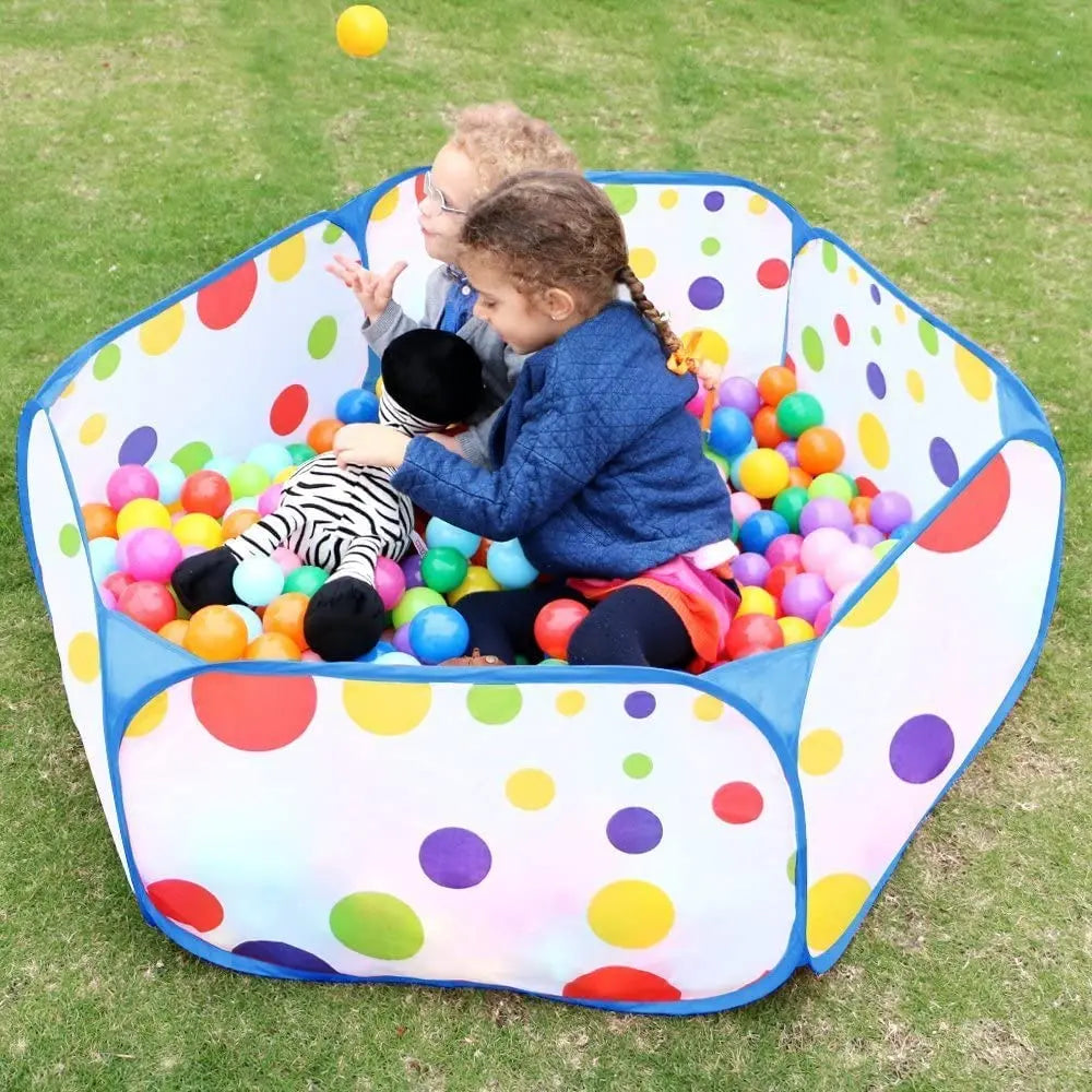 A colorful foldable kids ball pit play tent filled with plastic balls on a green lawn.