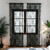 Black ruffled lace sheer curtains with floral embroidery covering a window in a bedroom setting
