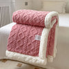 A pink and white double-layer fleece throw blanket folded on a bed