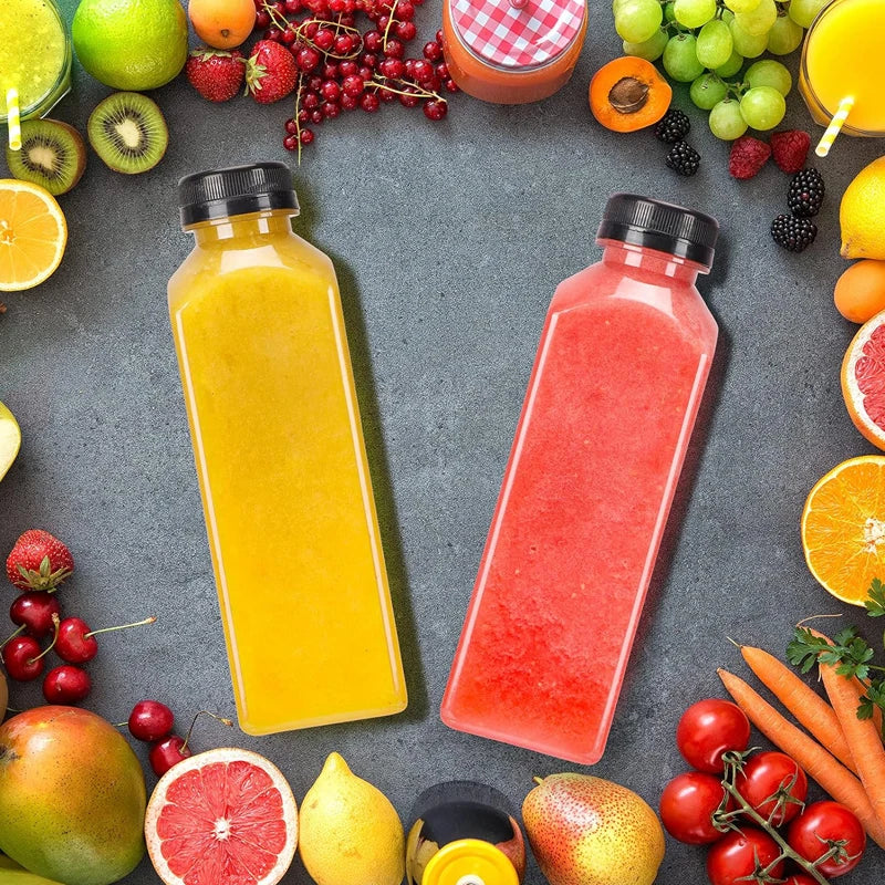 A flat lay of various fresh fruit juices and whole fruits in colorful plastic bottles on a gray surface.