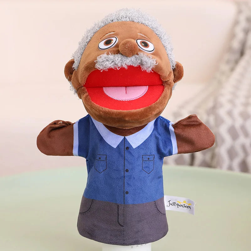 A soft plush hand puppet with gray hair and a red mouth, wearing a blue shirt and gray overalls.