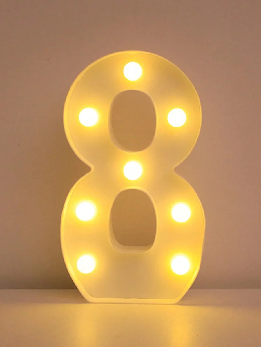 A glowing yellow LED letter night light shaped like the number 8, displayed on a surface.