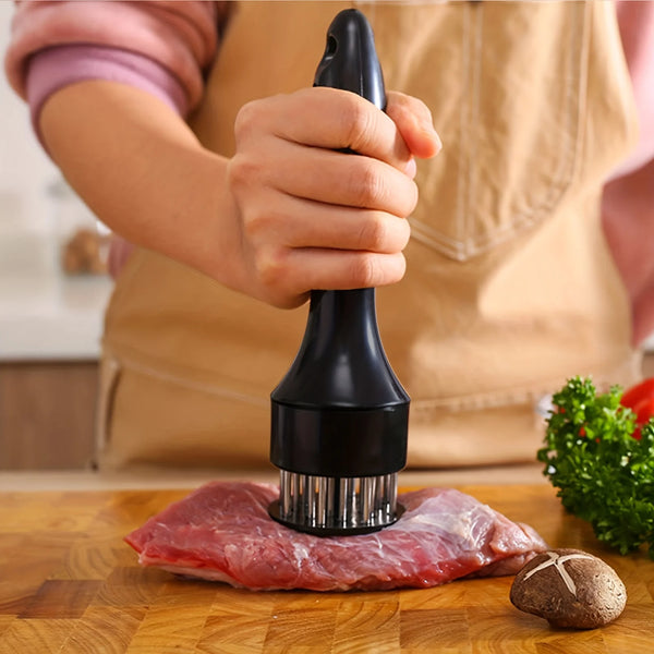 A hand holds a stainless steel meat tenderizer needle, preparing to use it on a piece of raw red meat.