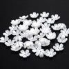 A scattered pile of 100 white acrylic pearl spacer beads for jewelry making