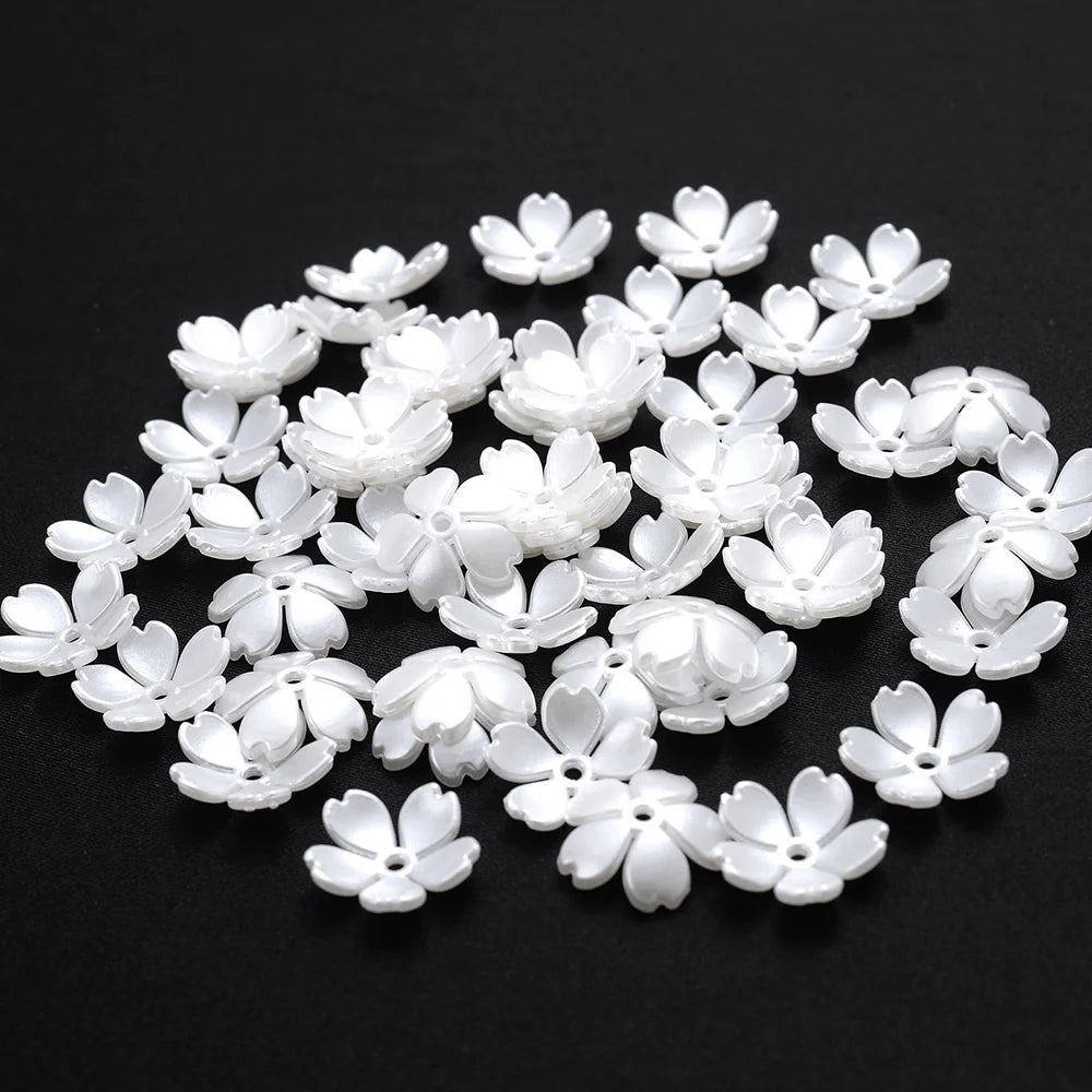 A scattered pile of 100 white acrylic pearl spacer beads for jewelry making