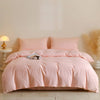 A pink quilted duvet cover set with matching pillowcases displayed on a bed.