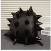 A black, spiky PU leather backpack with rivets resting on a gray surface.