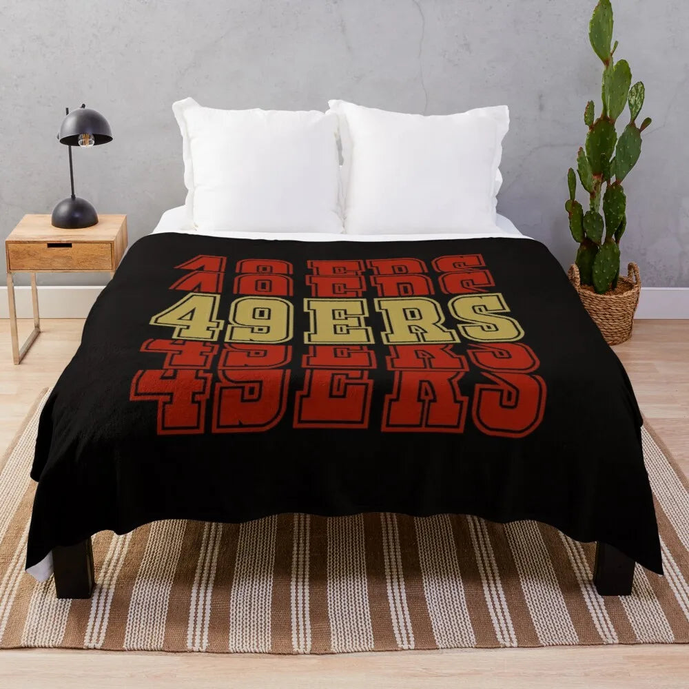 A black knit throw blanket featuring large text spelling out FORTY NINEERS.
