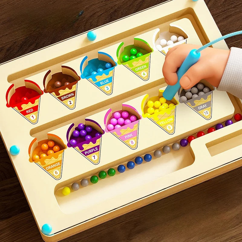 A hand is sorting colorful magnetic wooden cups into corresponding colored slots on a light wood maze board.