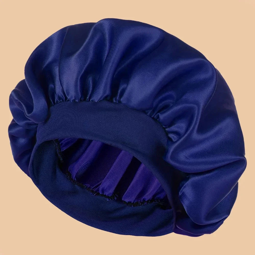 A deep blue satin wide brim shower cap folded and displayed against a light background.