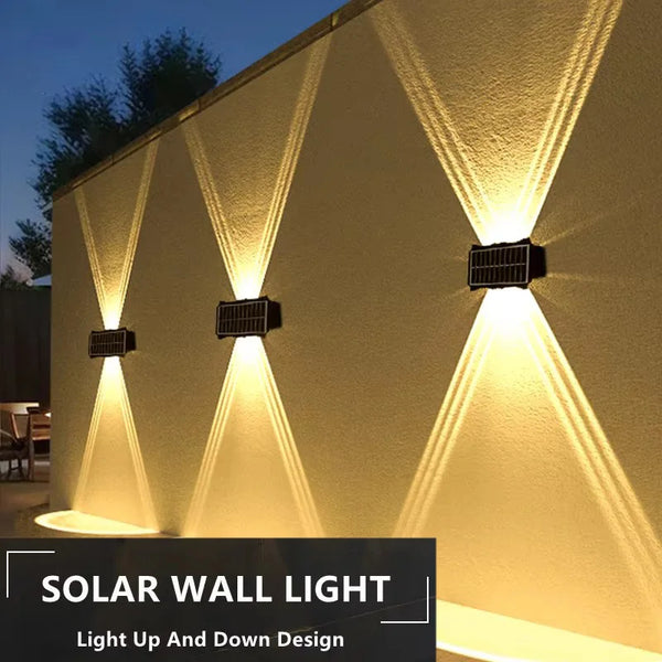 Luz de pared solar ilumina una pared texturizada con diseño de luz hacia arriba y abajo.