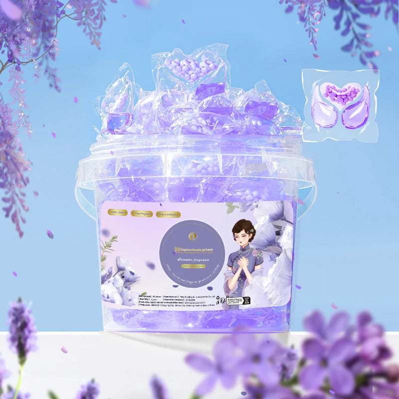 A clear plastic container filled with purple laundry pods and lavender flowers, featuring a label for 3-in-1 stain and odor r