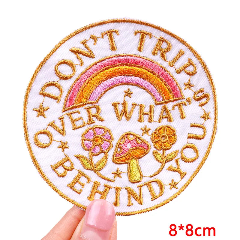 Pink and gold embroidered patch with the text Don't Trip Over What You Behind You