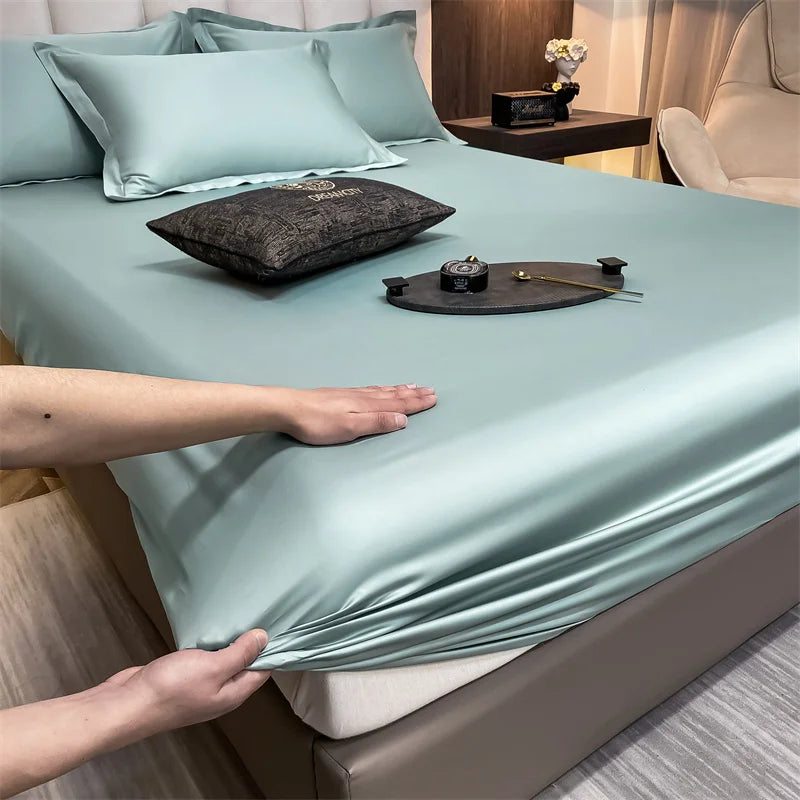 Un juego de sábanas ajustadas de algodón de lujo en color verde menta pálido esconde una cama.
