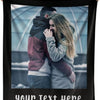 A black photo blanket featuring a couple embracing in an outdoor setting with a light blue background.