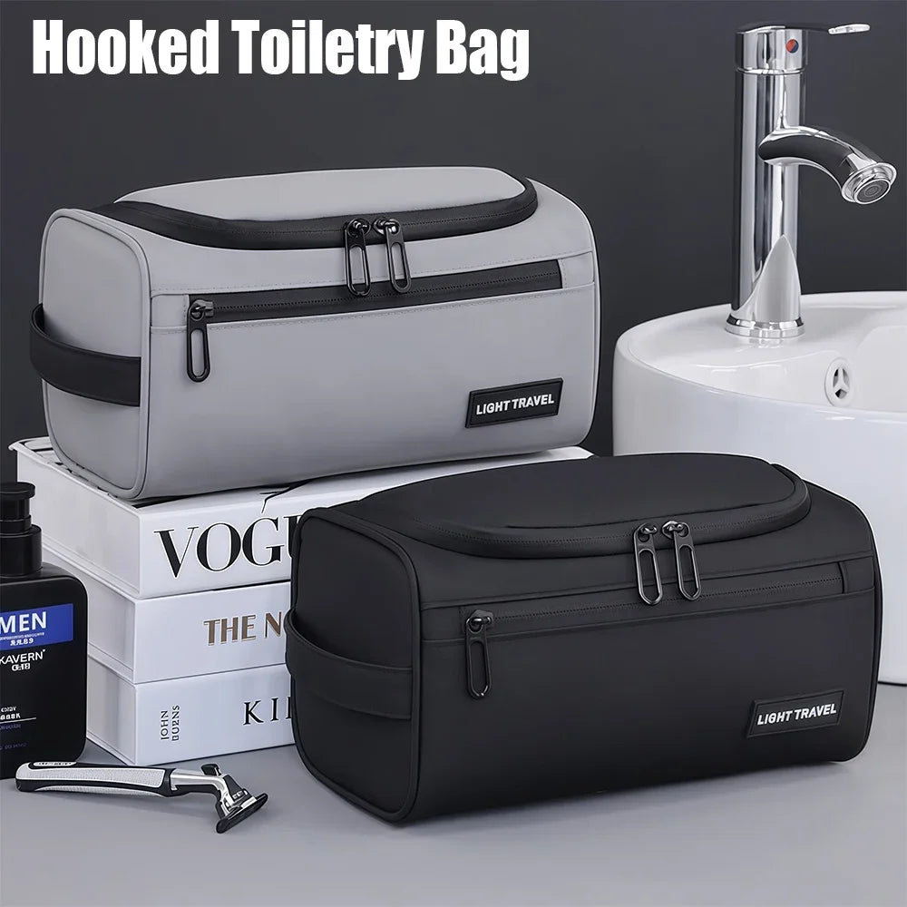 A gray and black hooked toiletry bag is shown next to a black light travel toiletry bag and a silver faucet.
