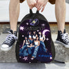 A black canvas backpack featuring the name KATSEYE in purple and white stars on the front, held by a person.