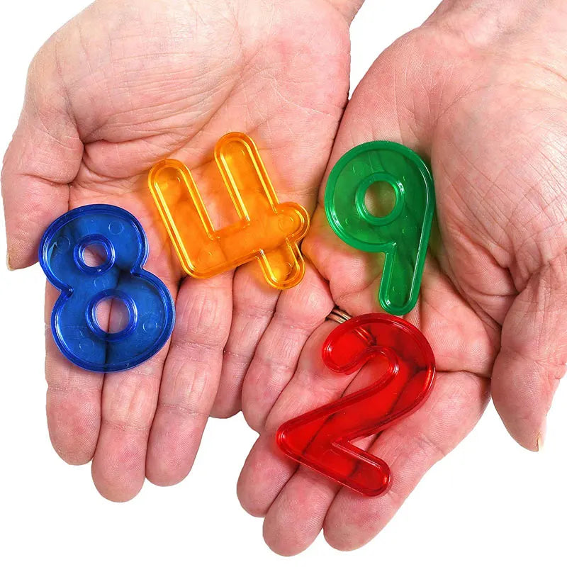 A pair of hands holds a set of colorful plastic numbers 4, 9, 8, and 2 for counting and math learning.