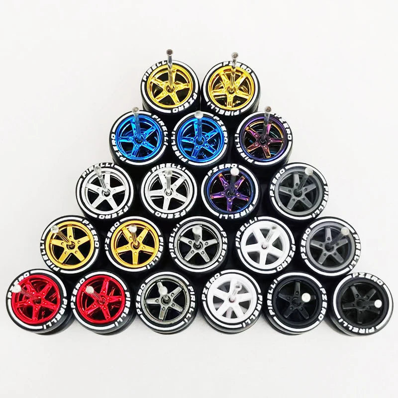 A collection of ten pairs of 1:64 scale alloy car wheels and tires in various colors including gold, blue, silver, and red.