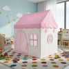 A pink floral playhouse tent with a pitched roof stands on a rug in a bright room.