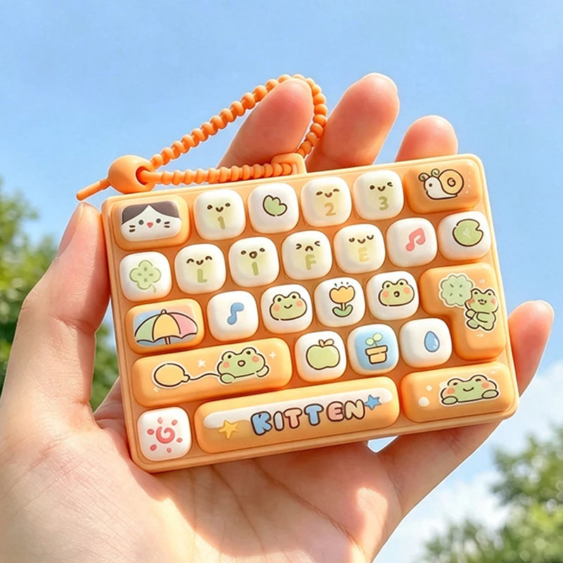 An orange cartoon keycap fidget keychain is held in a hand against a bright blue sky.