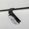 A black clip with a crystal rhinestone lens is shown against a light-colored surface.