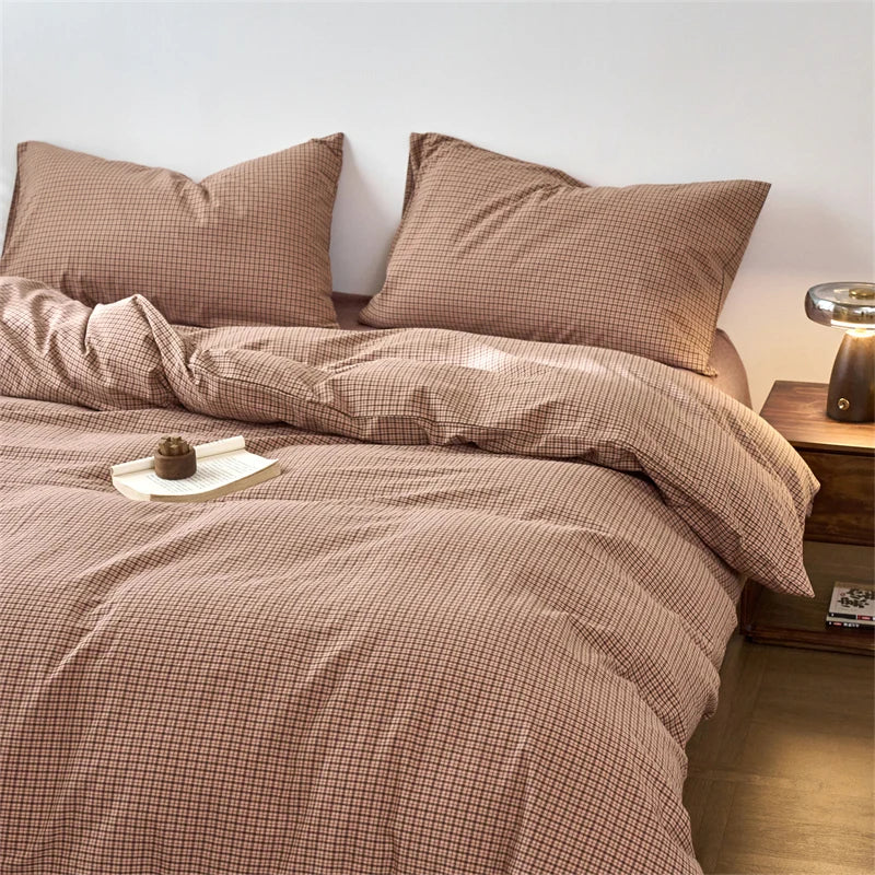 A beige plaid duvet cover with matching pillows and bedding on a bed.