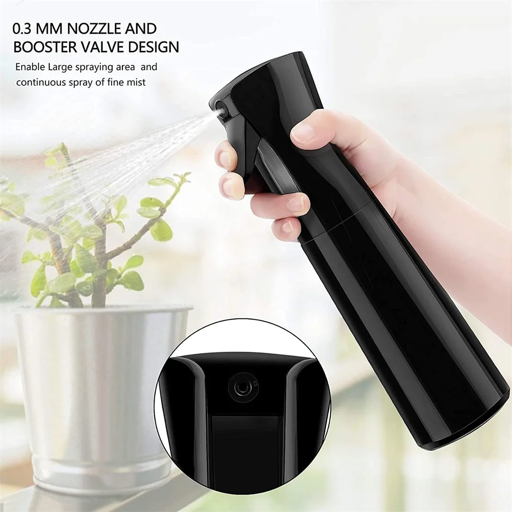 A hand holds a black mist spray bottle with a nozzle design, demonstrating its use for spraying plants.