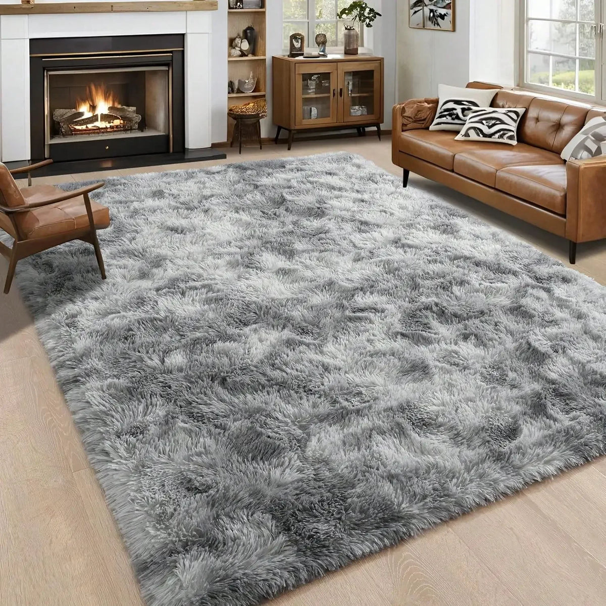 Plüschiger grauer Langflor-Teppich in einem Wohnzimmer mit einer Ledersofa und einem Kamin.