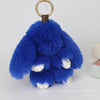 A fluffy blue angel bunny keychain featuring a pom pom tail and gold-colored hardware.